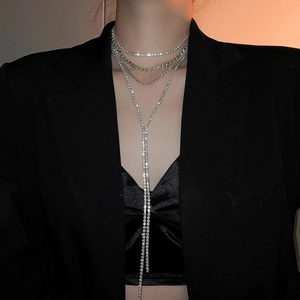 Detail of layered rhinestone tassel necklace with Y-shape chain on a model wearing black
