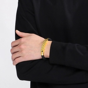 Detail of men's black braided bracelet with gold gear-textured stainless steel accents