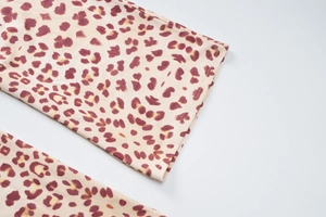 Close-up of leopard print fabric with precise stitching on the sleeve of the hooded cardigan