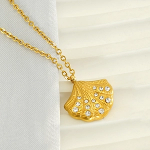 Elegant 18K gold-plated shell pendant necklace with sparkling diamonds on white fabric