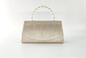 Detail of evening clutch with champagne glitter fabric and elegant pearl handle