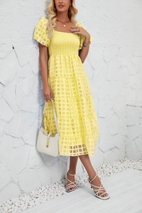 Detail shot of a yellow checkered dress with elastic smocked bodice and puff sleeves