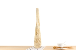 Detail of hollow woven paper rope bag with inner lining on a wooden table setup