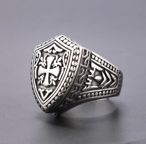 Macro side view of vintage stainless steel cross shield ring with detailed engravings