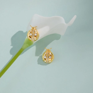 Détail des boucles d'oreilles coccinelle en métal doré avec cristaux scintillants