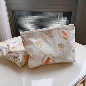 Detail of floral cotton makeup pouches with girl and teddy bear illustrations