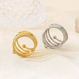 Macro detail of multi-layer spiral stainless steel rings with round beads in gold and silver