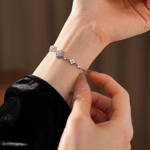 Detailed close-up of a silver flower bracelet with zircon stones on a model wrist