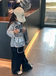 Silberne Kettentasche für Mädchen und trendiges Streetstyle-Outfit mit weiter Jeanshose