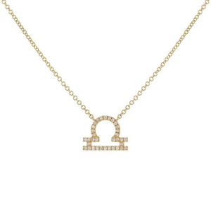 Macro view of gold Libra zodiac pendant featuring sparkling zircon stone settings