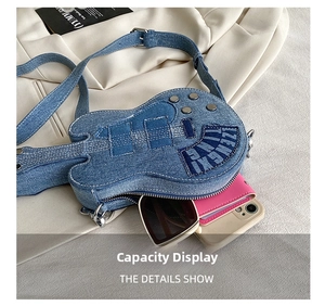 Detail view of denim guitar-shaped crossbody bag capacity showing phone and wallet
