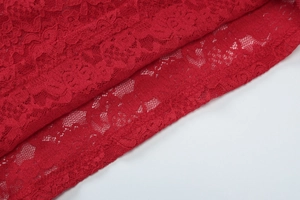 Gros plan détaillé du tissu en dentelle rouge révélant la texture et les coutures fines