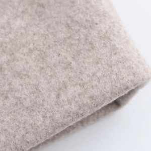 Detailed macro view of soft beige wool blend fabric texture on elegant winter overcoat