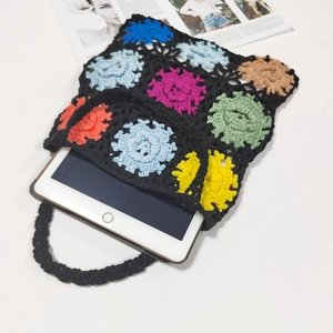 Detailed close-up of a colorful handmade crochet tote bag featuring multi-color floral patterns