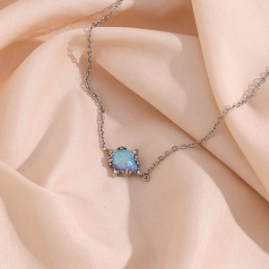 Close-up detail of a stainless steel teardrop opal pendant necklace with delicate chain.