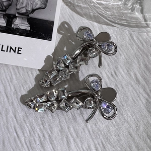 Detailed close-up of silver bow hair clips with shimmering crystal rhinestones