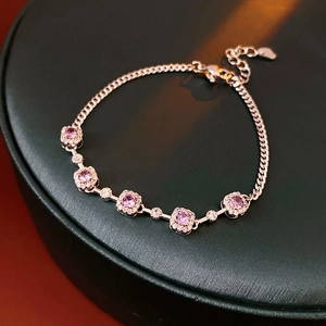 Macro detail of purple zircon bracelet with silver chain and heart-shaped adjustable charm