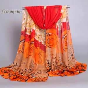 Detail of elegant orange red chiffon scarf featuring vibrant large rose floral prints