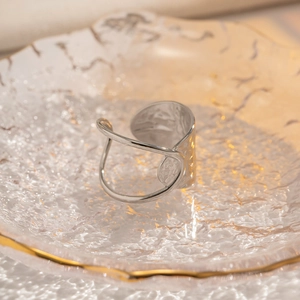 Detail of silver irregular hammered texture on geometric open stainless steel ring
