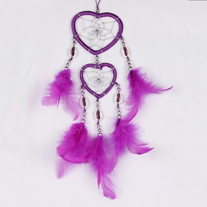 Handmade purple heart-shaped dream catcher with feathers and shell beads on white background