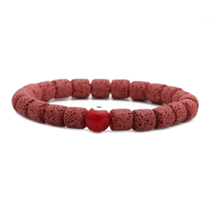 Detailansicht eines Lavastein-Armbands mit einer roten Evil Eye Perle aus Glas