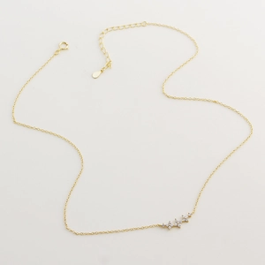 Detail of a dainty gold star pendant necklace with clear crystals and a spring clasp