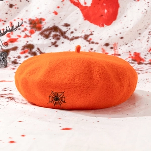 Close-up of orange wool beret featuring detailed black spider web embroidery for Halloween