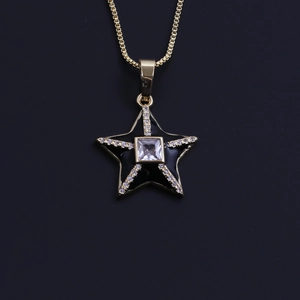 Macro detail of 18k gold plated star pendant with black enamel and clear cubic zirconia