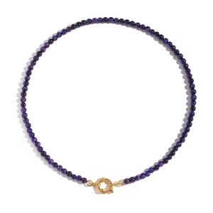 Macro shot of deep purple natural stone beads necklace with gold clasp on white background