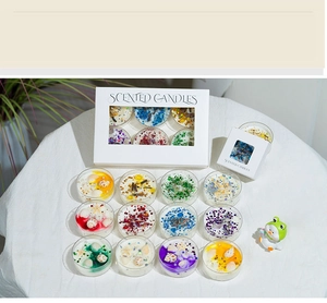 Top view of handmade scented candles with seashells, dried flowers and shiny sequins