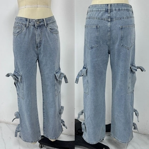 Detailed view of light blue denim cargo pants with side pockets and bow ribbon accents