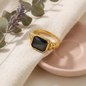 Macro detail of a vintage gold twisted ring with a large rectangular black gemstone