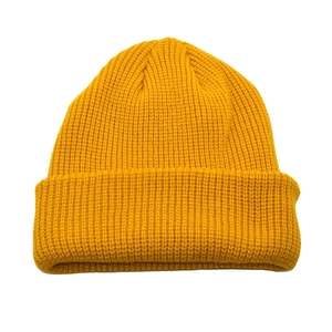 Detail of ginger yellow ribbed knit beanie showing thick wool texture and folded cuff edge