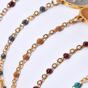 Macro shot of colorful enamel beads and golden stainless steel link bracelet detail