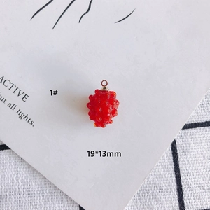 Detail view of a 19x13mm red berry glass pendant with a gold ring for DIY jewelry