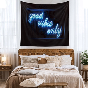 Detail of neon blue 'good vibes only' tapestry hanging in a cozy modern bedroom