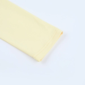 Detail view of double-stitched cuffs on light yellow long sleeve ruffled slim dress