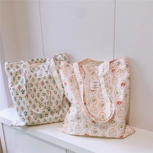 Close-up of floral cotton tote bags with green and orange vintage botanical prints