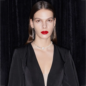 Detail of elegant camellia floral necklace and sparkling drop earrings on black velvet