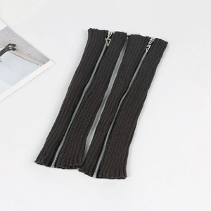 Detail view of dark grey knitted leg warmers featuring full-length silver zippers