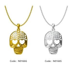 Détail de pendentifs tête de mort hip-hop or et argent avec yeux en cœur et strass incrustés