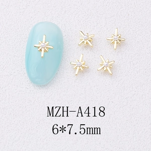 Macro view of gold cross star nail charms with 6x7.5mm size and pearl centerpiece
