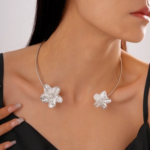 Detail eines silbernen Metall-Chokers mit Hammerschlag-Blumendesign an einem Modell