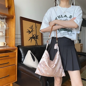 Detailed close-up of pink jacquard butterfly shoulder bag with silk texture and bow accent