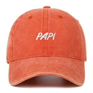 Detailed close-up of white 3D embroidery and washed cotton texture on vintage orange cap