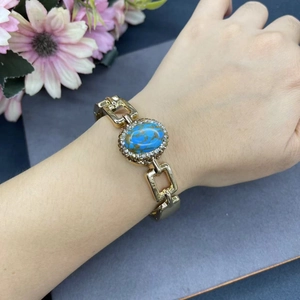 Elegante bracciale a catena dorata con una pietra turchese ovale e cristalli scintillanti