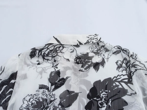 Detail of vintage floral print chiffon blouse with ruffled collar and long sleeves