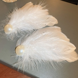 Elegant white feather hair clips with pearls on a textured background, pair set