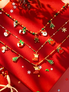 Détail de colliers de Noël avec pendentifs Père Noël et sapin en émail rouge et vert