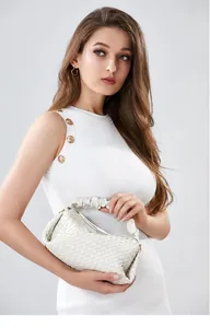 Detail of cream woven leather handbag with ruched handle and intricate pleated texture